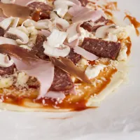 close-up-mushroom-ham-salami-cheese-raw-pizza-bread-parchment-paper